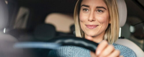 hero-blonde-lady-smiling-inside-car-min